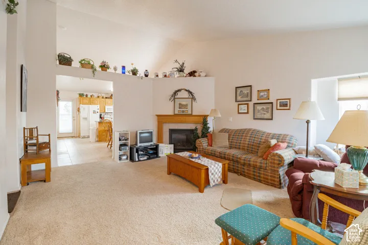 Vaulted ceilings, built-in fireplace with a wooden mantel, and elevated display ledge