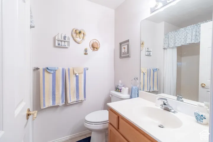 Bathroom featuring a wood-finish vanity with a molded countertop and integrated sink, a full-width vanity mirror, a multi-light fixture, and a tub-shower combination