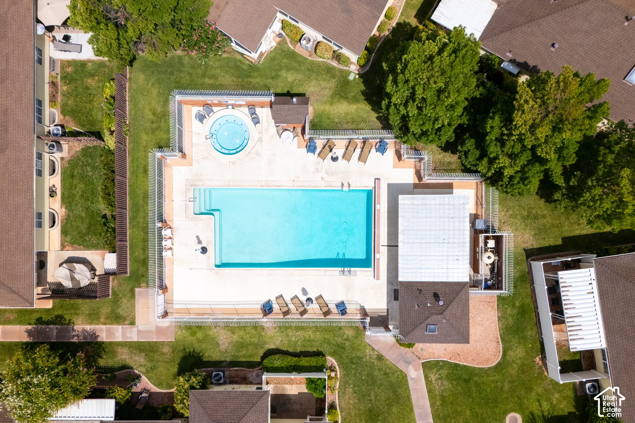 Outdoor swimming pool, separate circular spa, concrete decking, and perimeter fencing