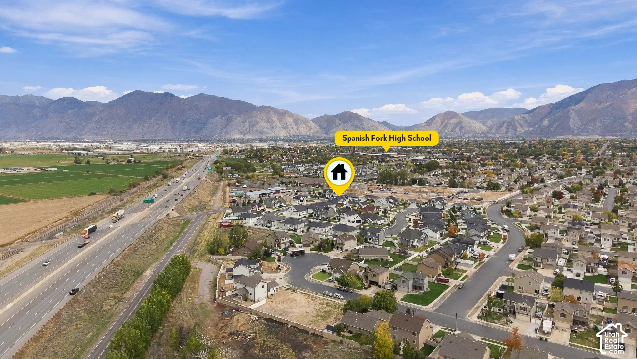 Aerial view of suburban residential neighborhood featuring mountain topography and proximity to regional transit infrastructure