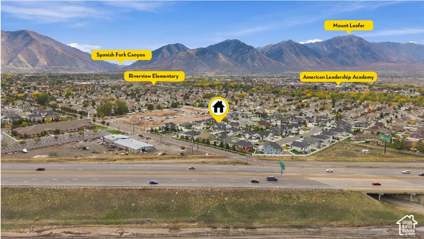 Aerial perspective featuring a residential lot in a suburban setting, highlighted by a backdrop of mountain ranges