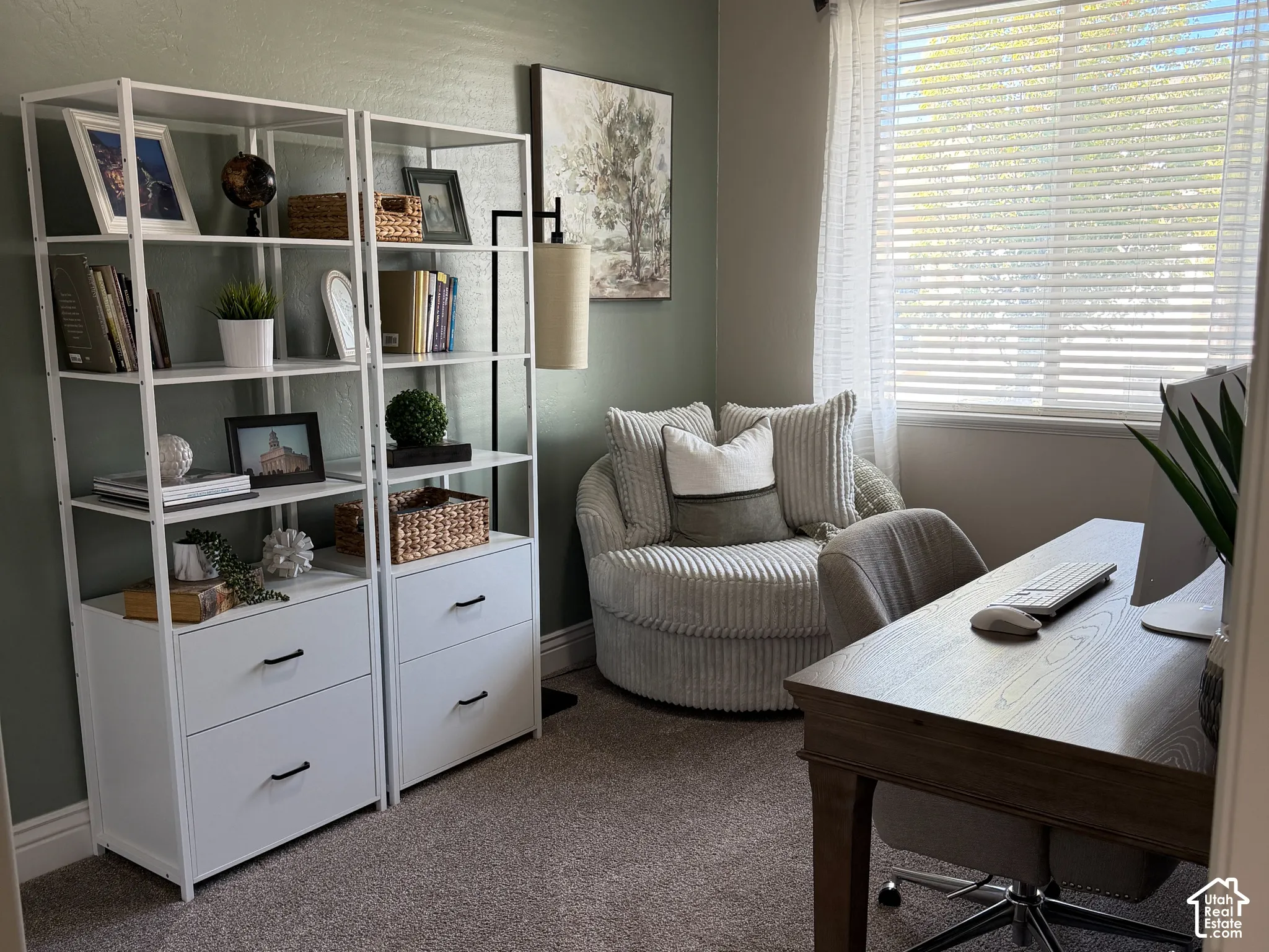 Room featuring neutral wall-to-wall carpeting and a sage green accent wall with a window providing natural light