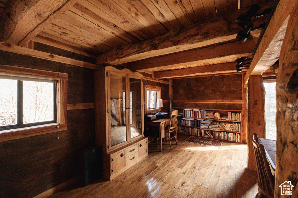 Exposed timber ceiling beams, wood-finish flooring, paneled wood walls, and integrated wood cabinetry