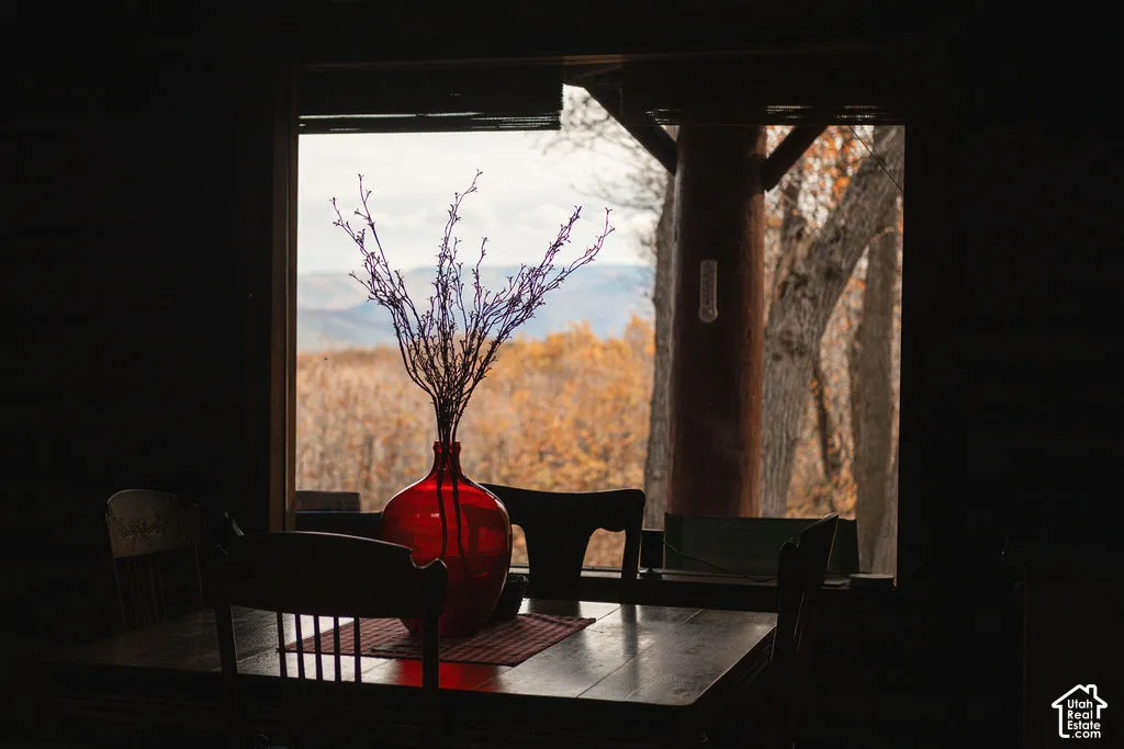 Large window with timber-framed structural column featuring panoramic mountain and forest scenery