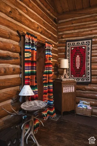Hand-hewn log walls with mortar chinking and wood plank flooring