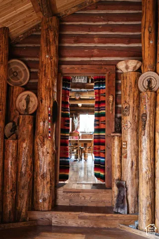 Hand-hewn log wall construction featuring exposed timber support pillars, wood-finish flooring, and natural timber ceiling planking