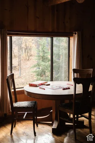 Large picture window featuring natural scenery, wood-plank walls, and wood-finish flooring