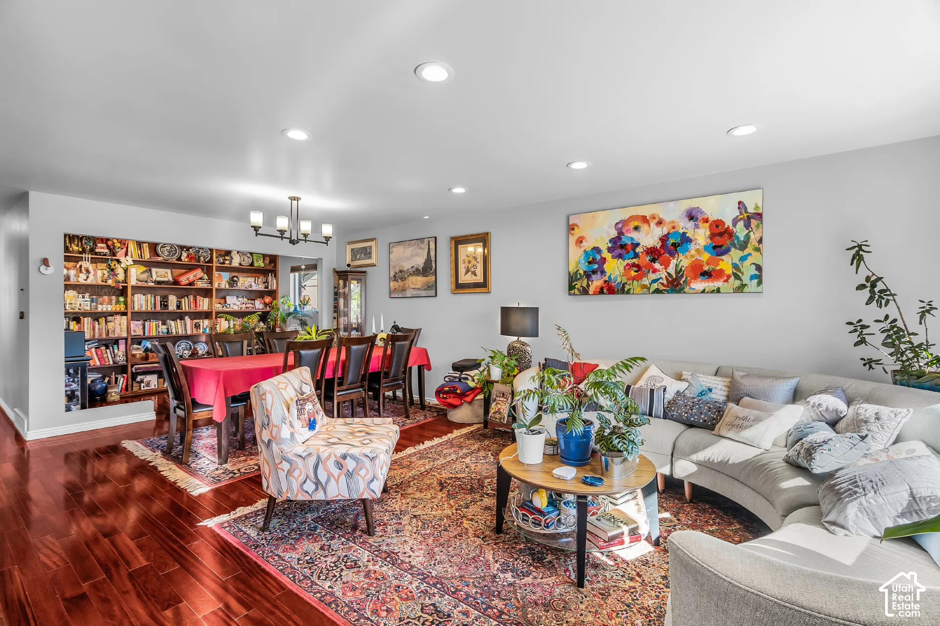 Open-concept interior featuring wood-finish flooring, recessed lighting, a multi-arm chandelier, and a built-in recessed wall shelving unit
