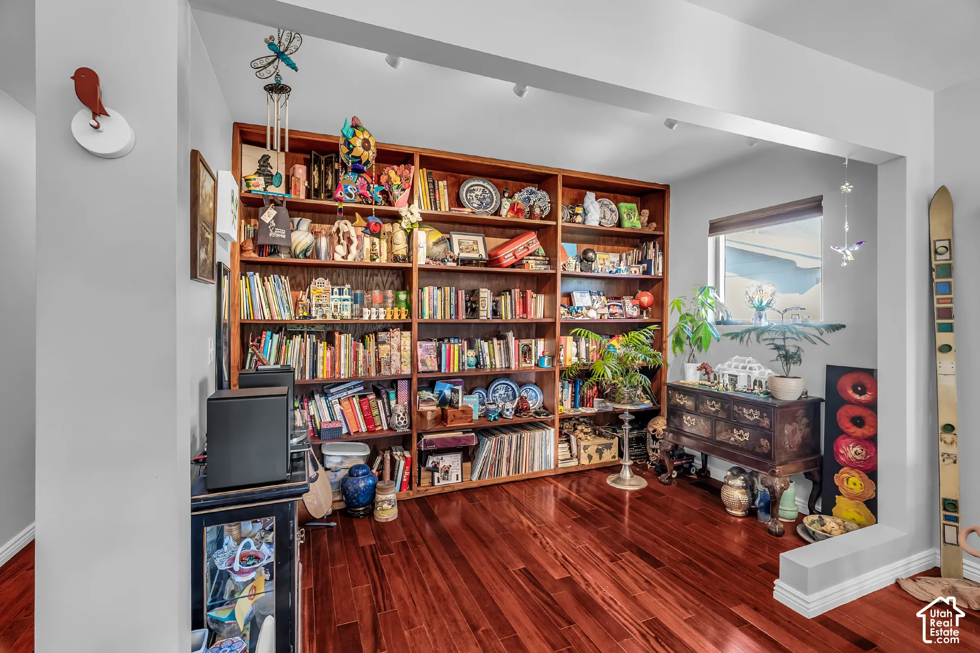 Built-in wood shelving unit with recessed overhead track lighting and wood-finish flooring