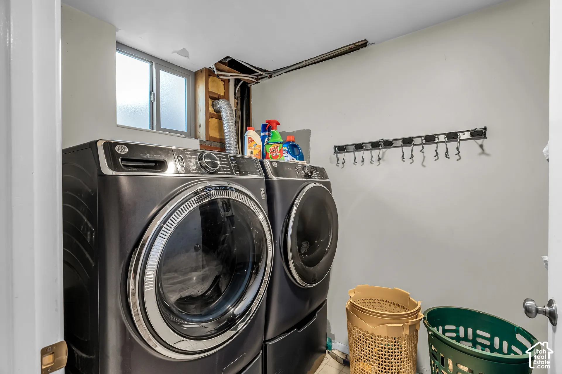 Utility area featuring a sliding window and a wall-mounted hook rack