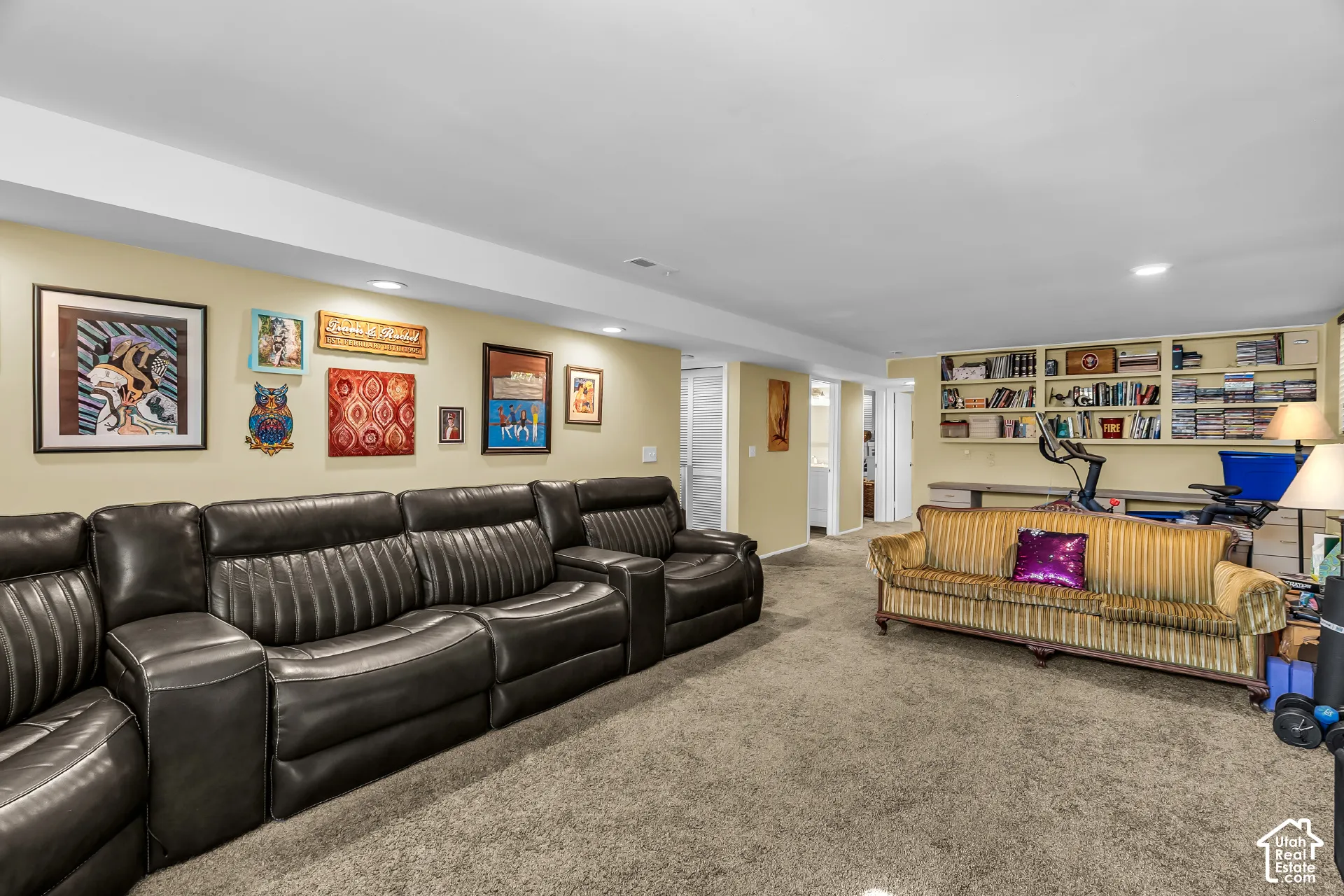 Open-concept interior featuring recessed lighting, wall-to-wall carpeting, and custom built-in cabinetry with integrated shelving and desk space
