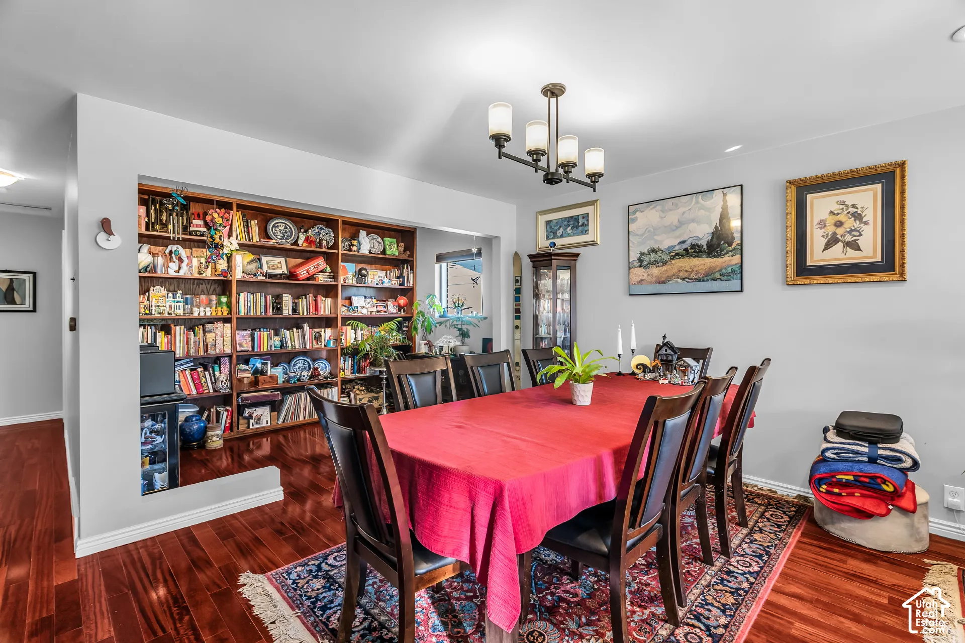 Built-in wooden shelving, wood-finish flooring, and five-light metal chandelier