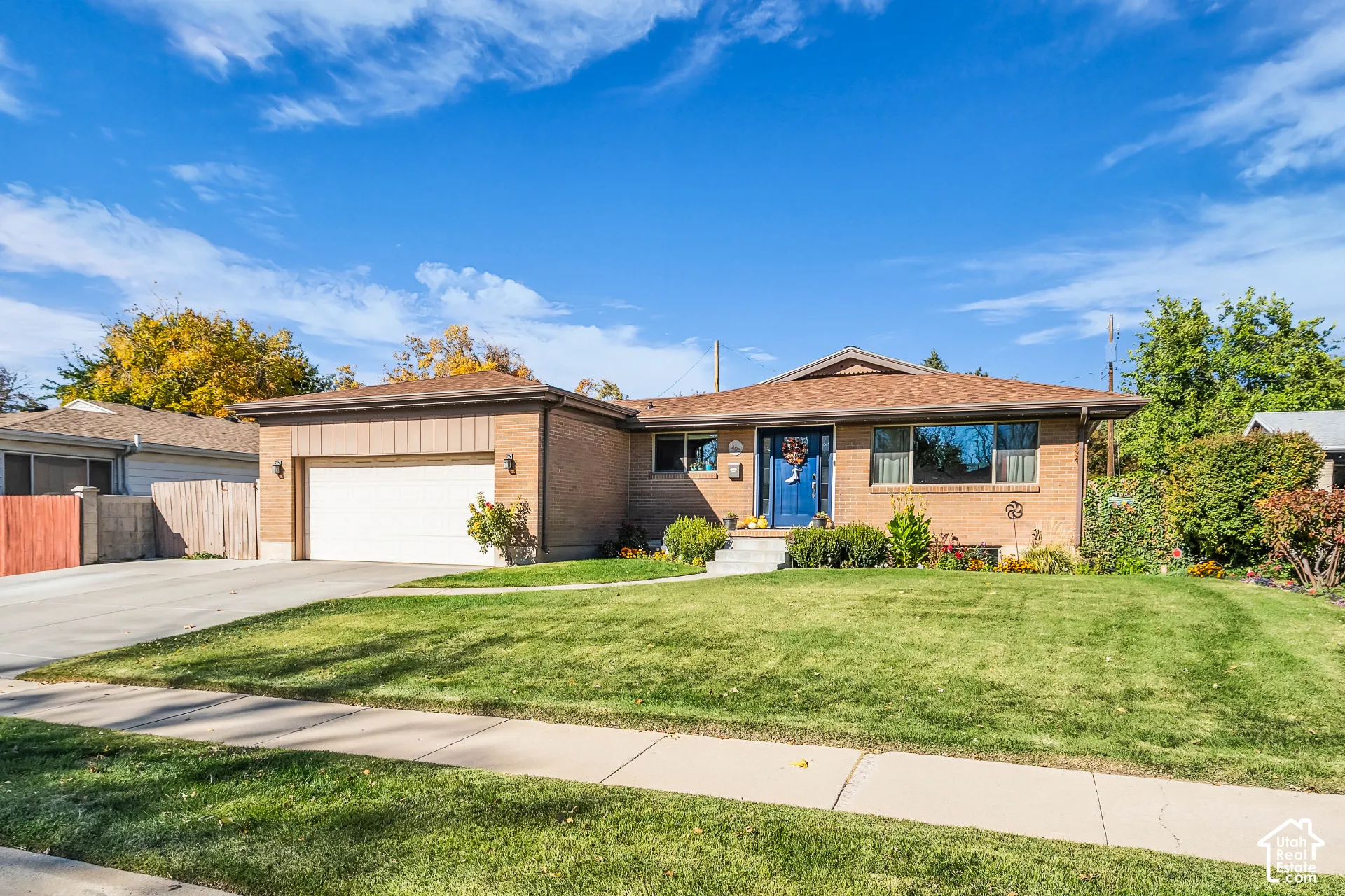 Single-story brick exterior featuring a multi-paneled garage door, asphalt shingle roof, concrete driveway, and front entryway