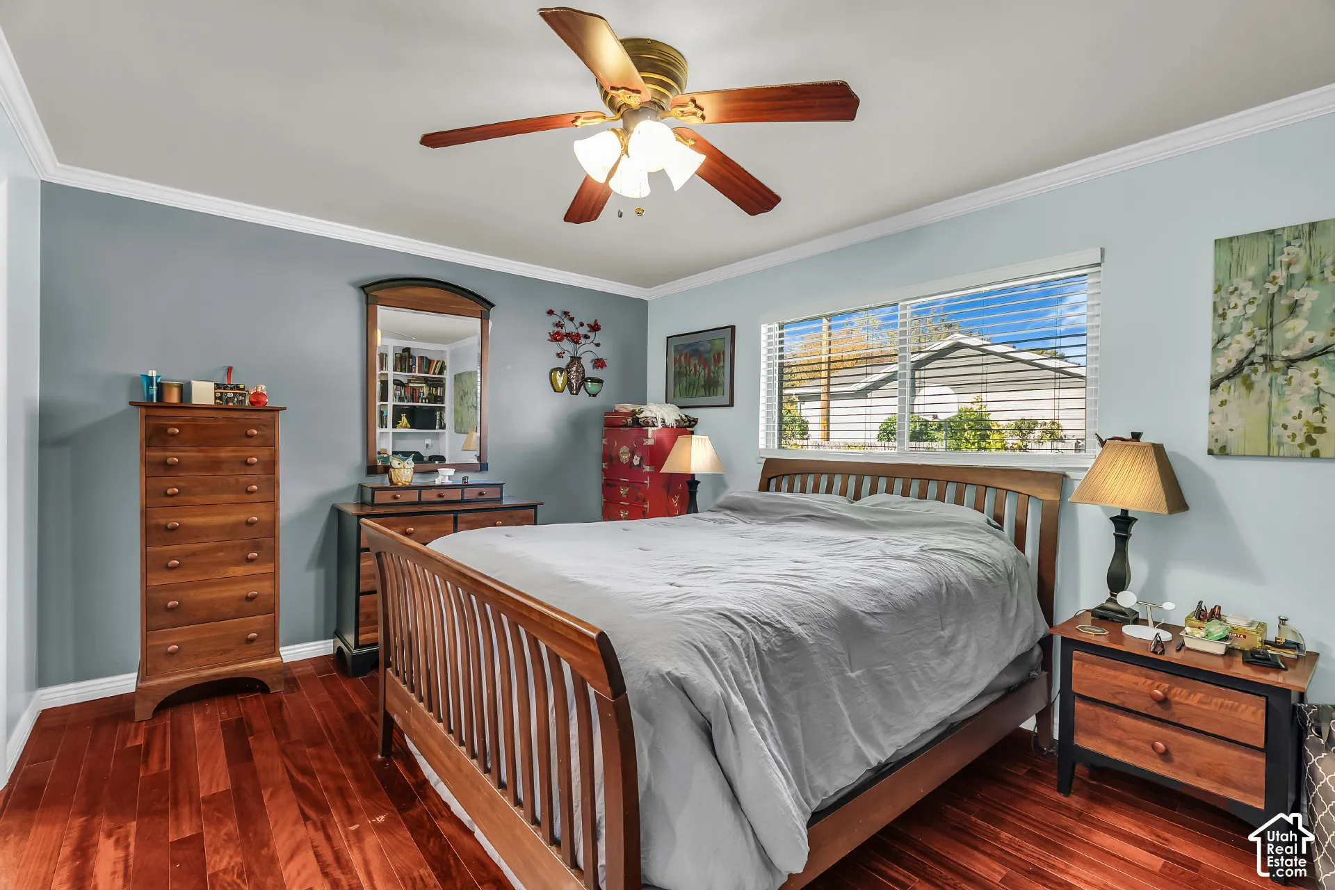 Room featuring wood-finish flooring, ceiling fan with integrated lighting, crown molding, and sliding window