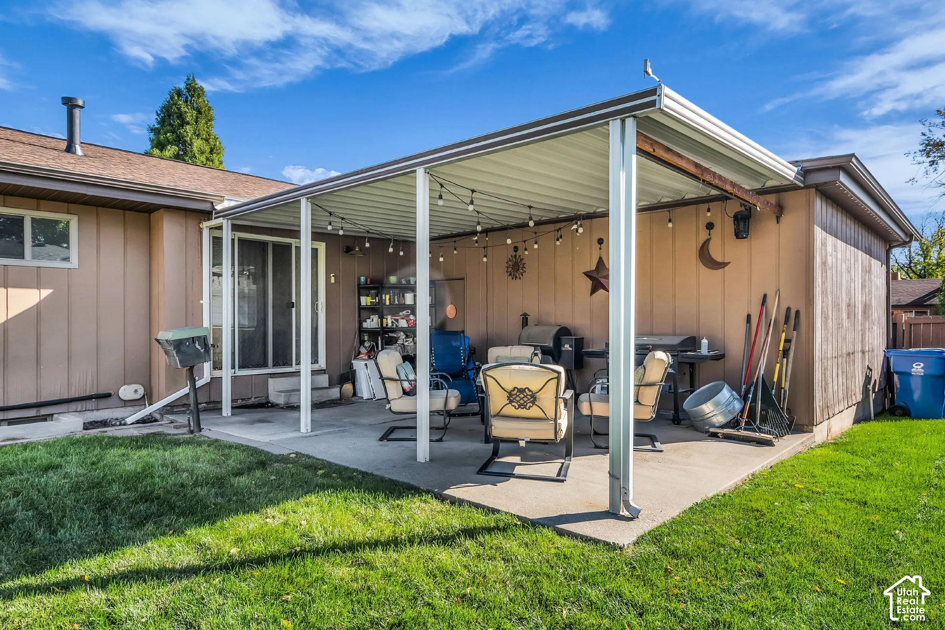 Concrete patio featuring a metal-framed covered structure and sliding glass doors