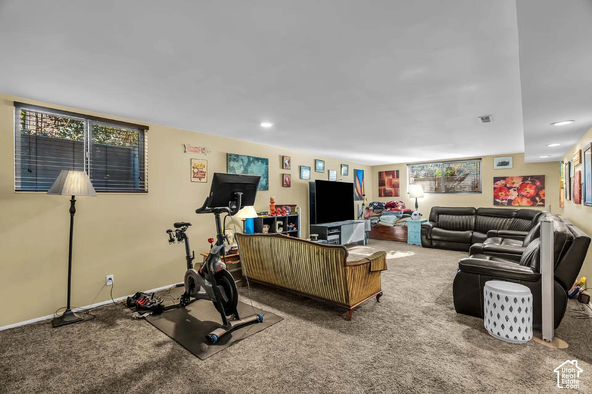 Spacious carpeted room featuring recessed lighting and dual windows with horizontal blinds