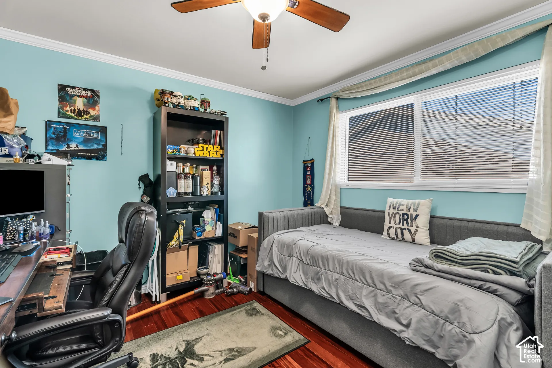 Room featuring wood-finish flooring, crown molding, horizontal window blinds, and a ceiling fan
