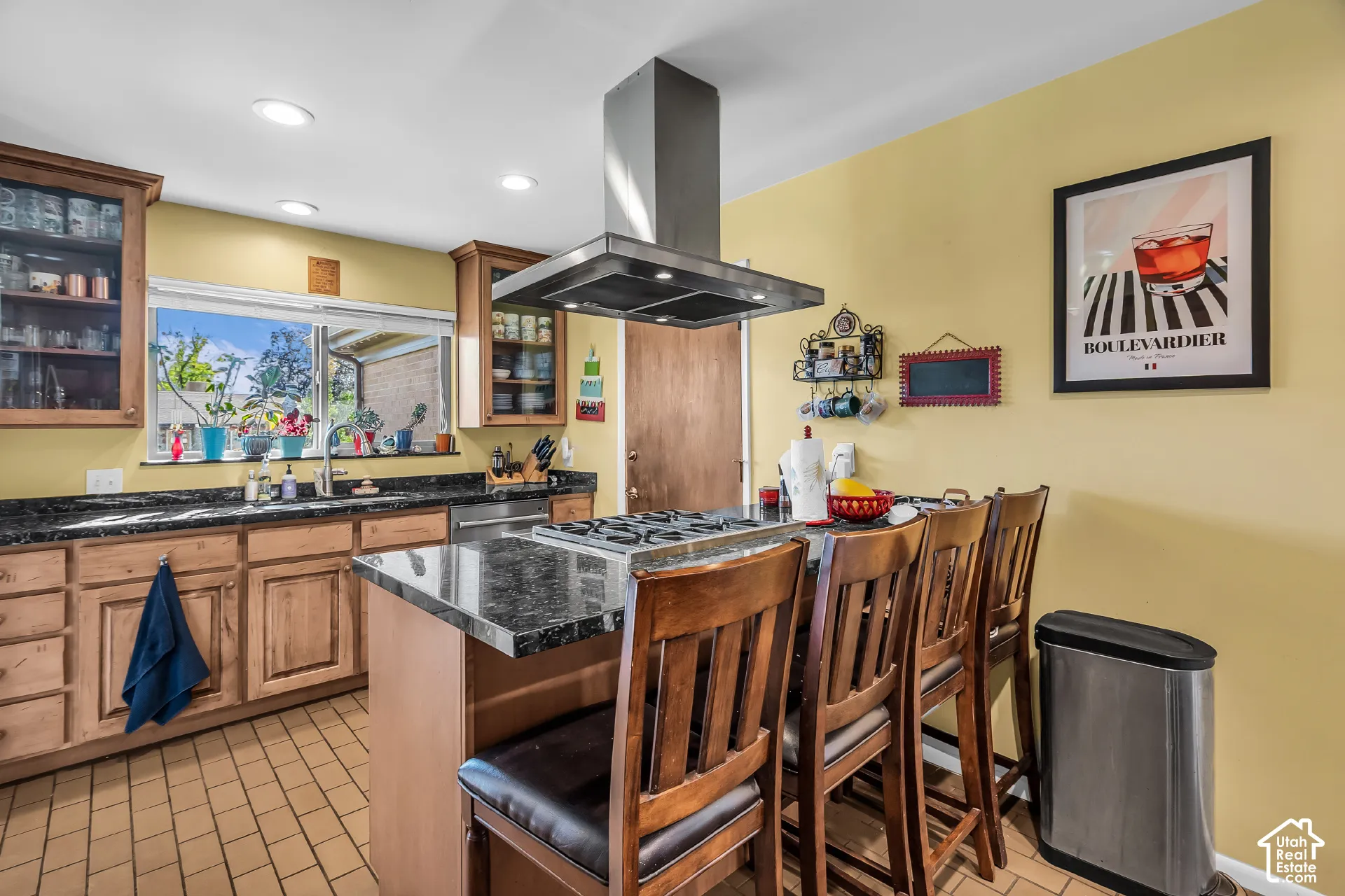 Kitchen featuring wood cabinetry, stone countertops, a center island with a built-in cooktop, a stainless steel chimney-style range hood, and recessed lighting