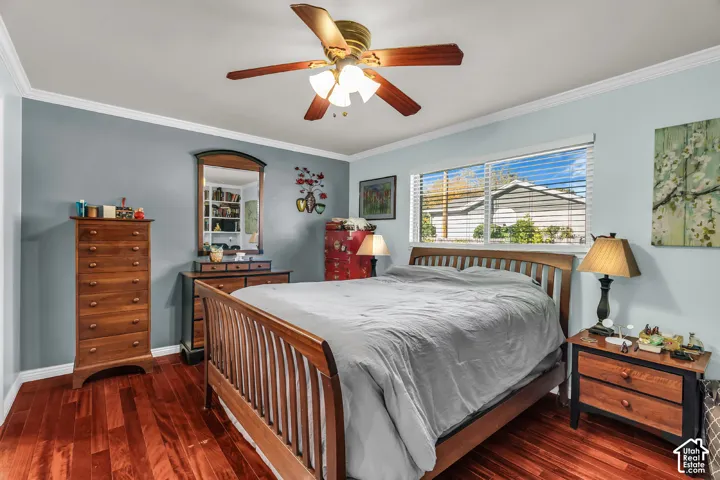 Room featuring wood-finish flooring, ceiling fan with integrated lighting, crown molding, and sliding window