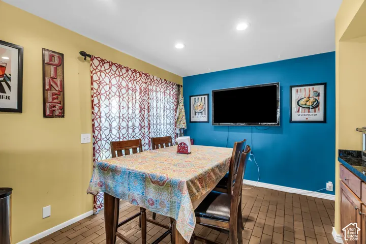 Recessed ceiling lighting, sliding glass door with patterned drapery, and tile flooring