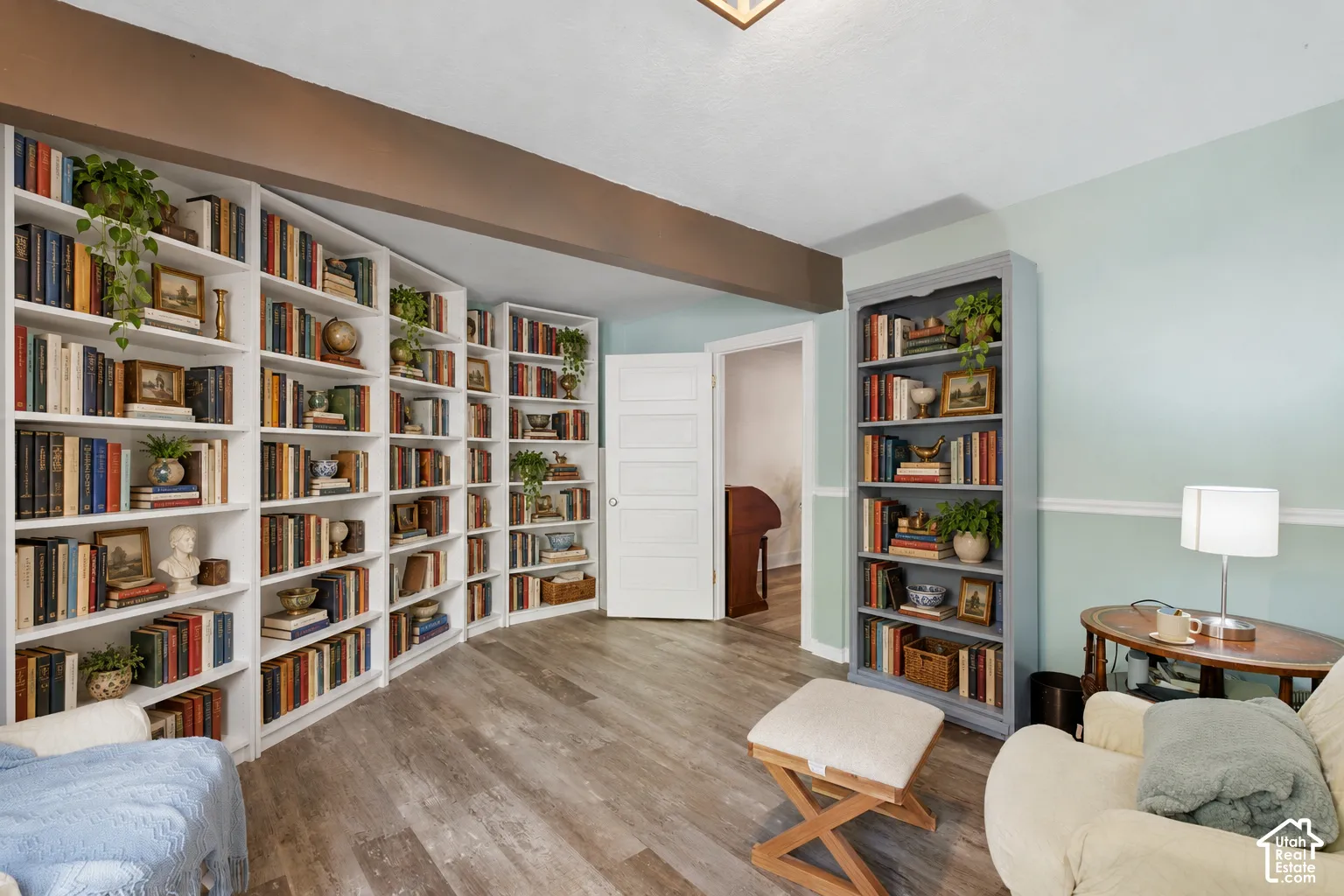 Floor-to-ceiling built-in white bookshelves, wood-finish flooring,can be used as an additional bedroom