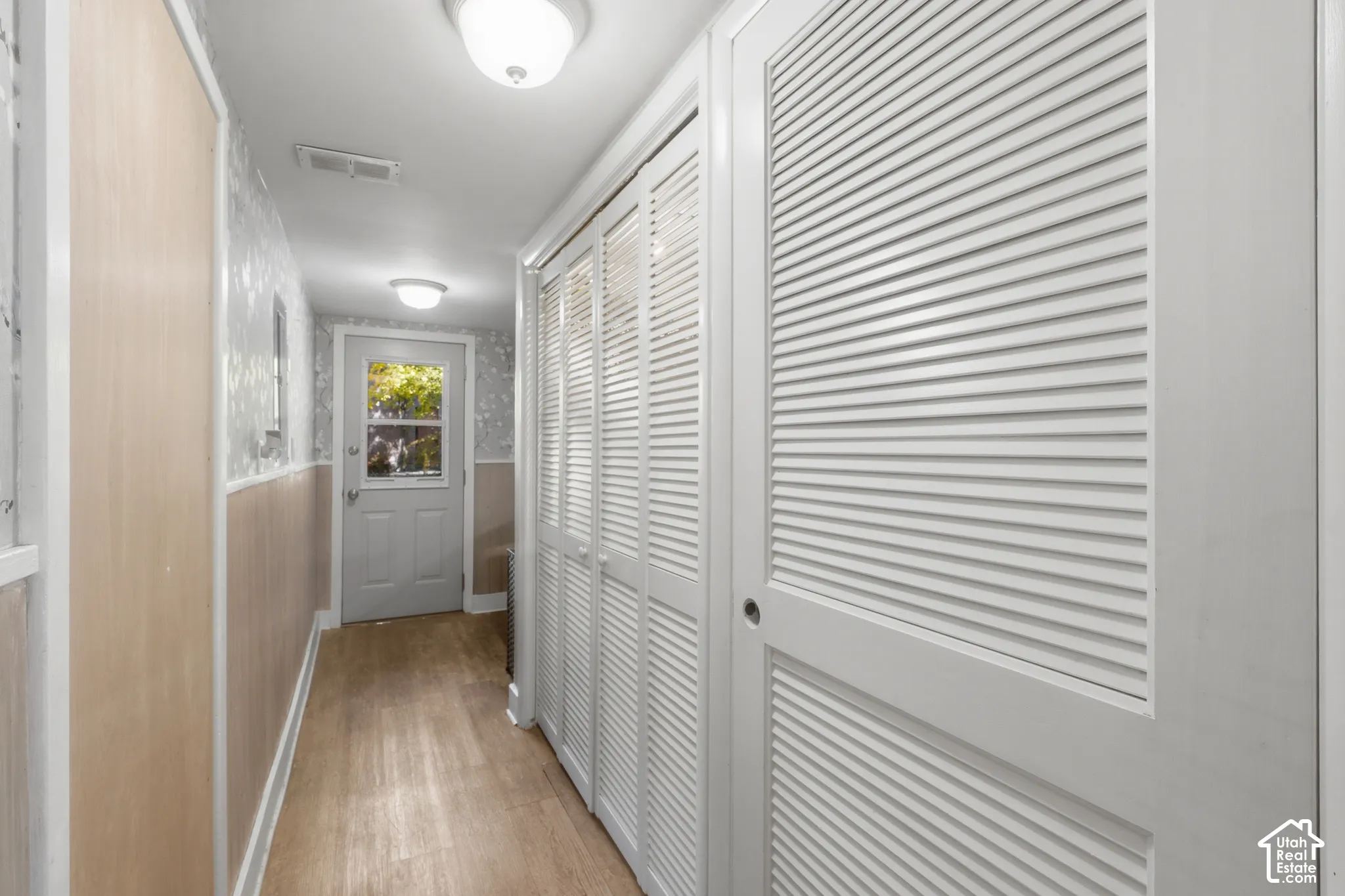 Hallway featuring laundry room