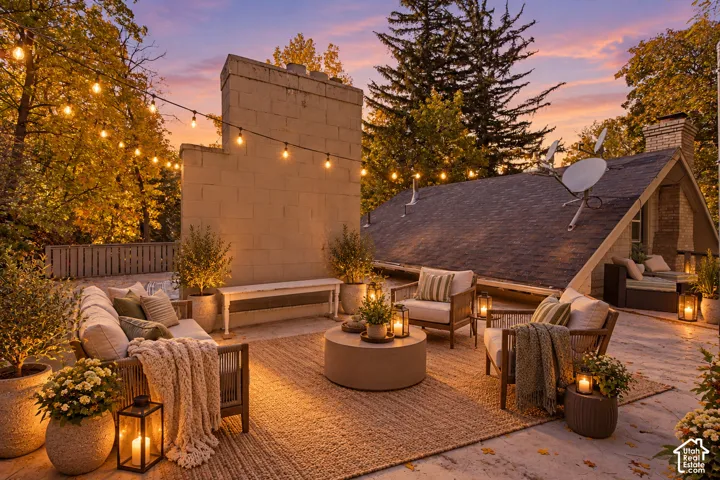 Expansive rooftop terrace featuring a masonry chimney, shingled roofline, and perimeter wooden fencing