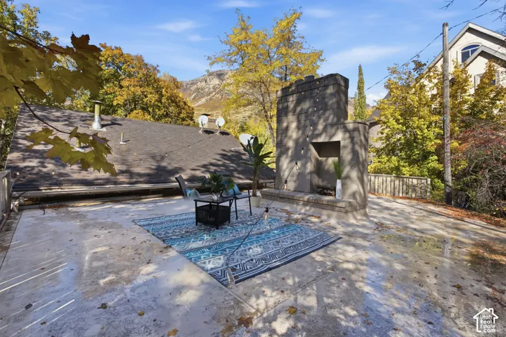 Expansive rooftop deck featuring a fireplace and mountainous backdrop
