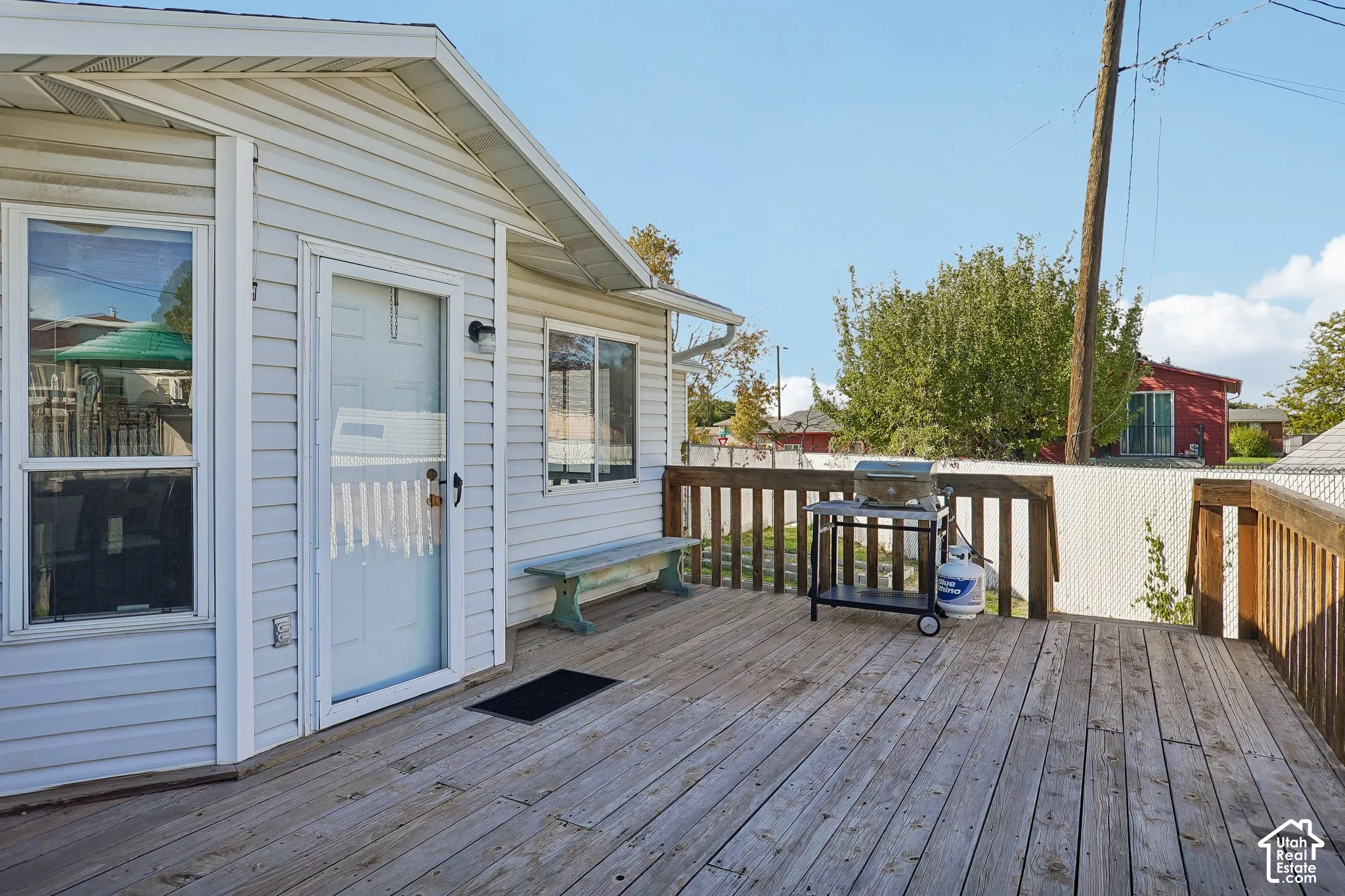 Elevated wood-plank deck featuring a wooden railing and light-colored vinyl siding exterior