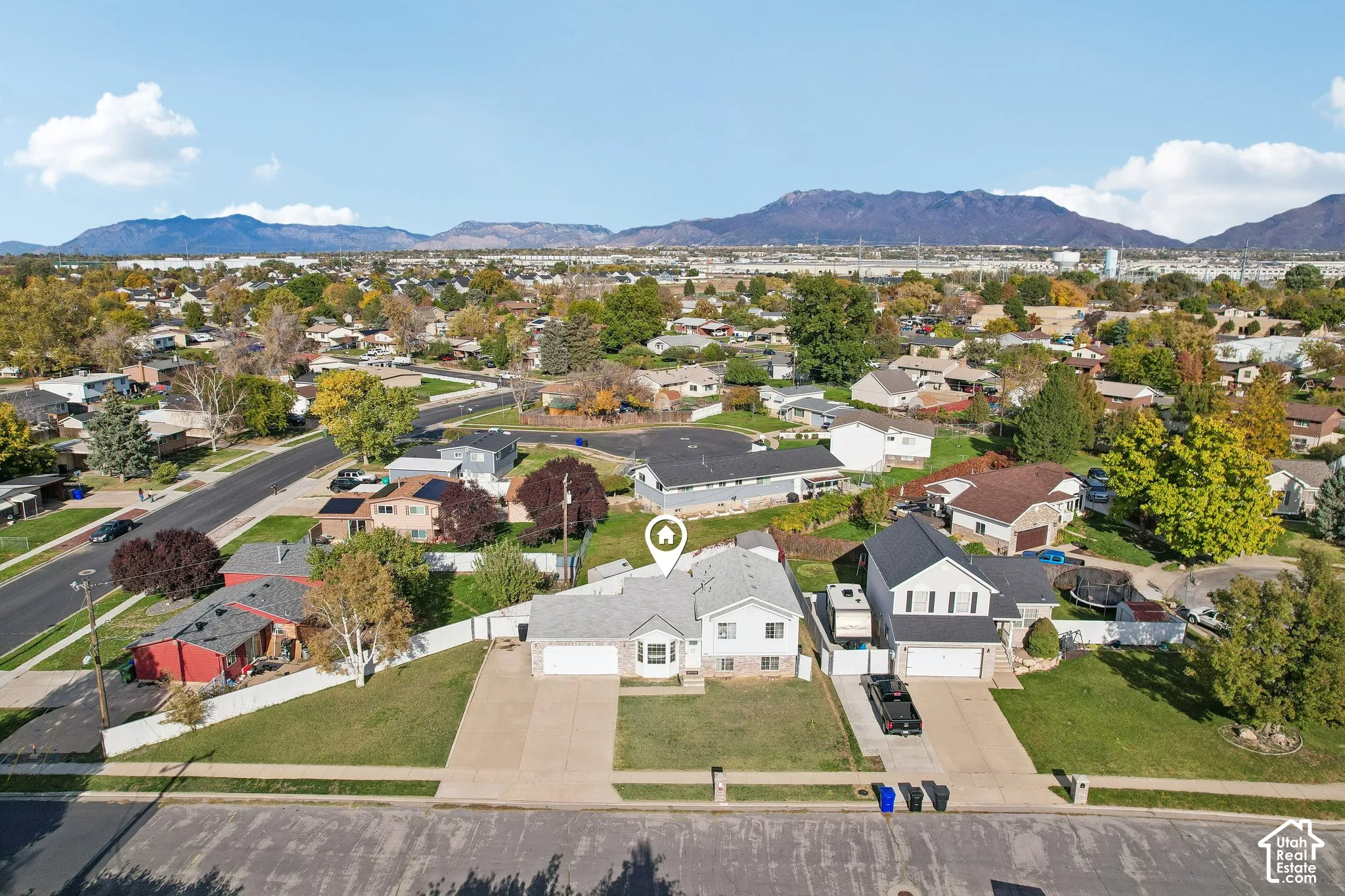 Single-family residence featuring a split-level exterior, concrete driveway, attached garage, and prominent mountain backdrop