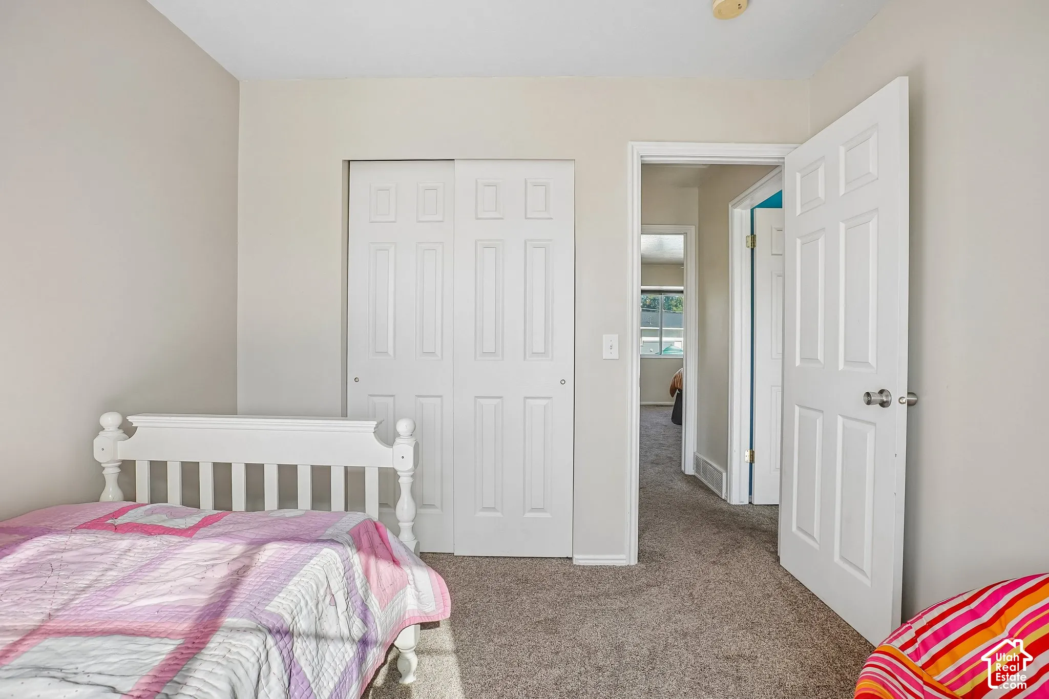 Neutral-toned walls, wall-to-wall carpeting, and sliding panel closet doors