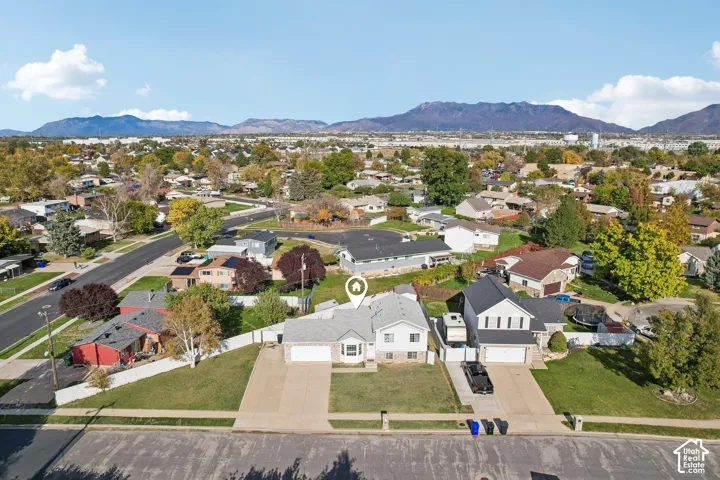 Single-family residence featuring a split-level exterior, concrete driveway, attached garage, and prominent mountain backdrop