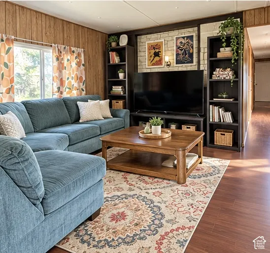 Wood-paneled walls, built-in shelving flanking a stone-finish accent wall, and wood-finish flooring