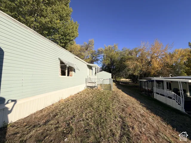 Light blue horizontal siding, metal window awnings, and chain-link fencing