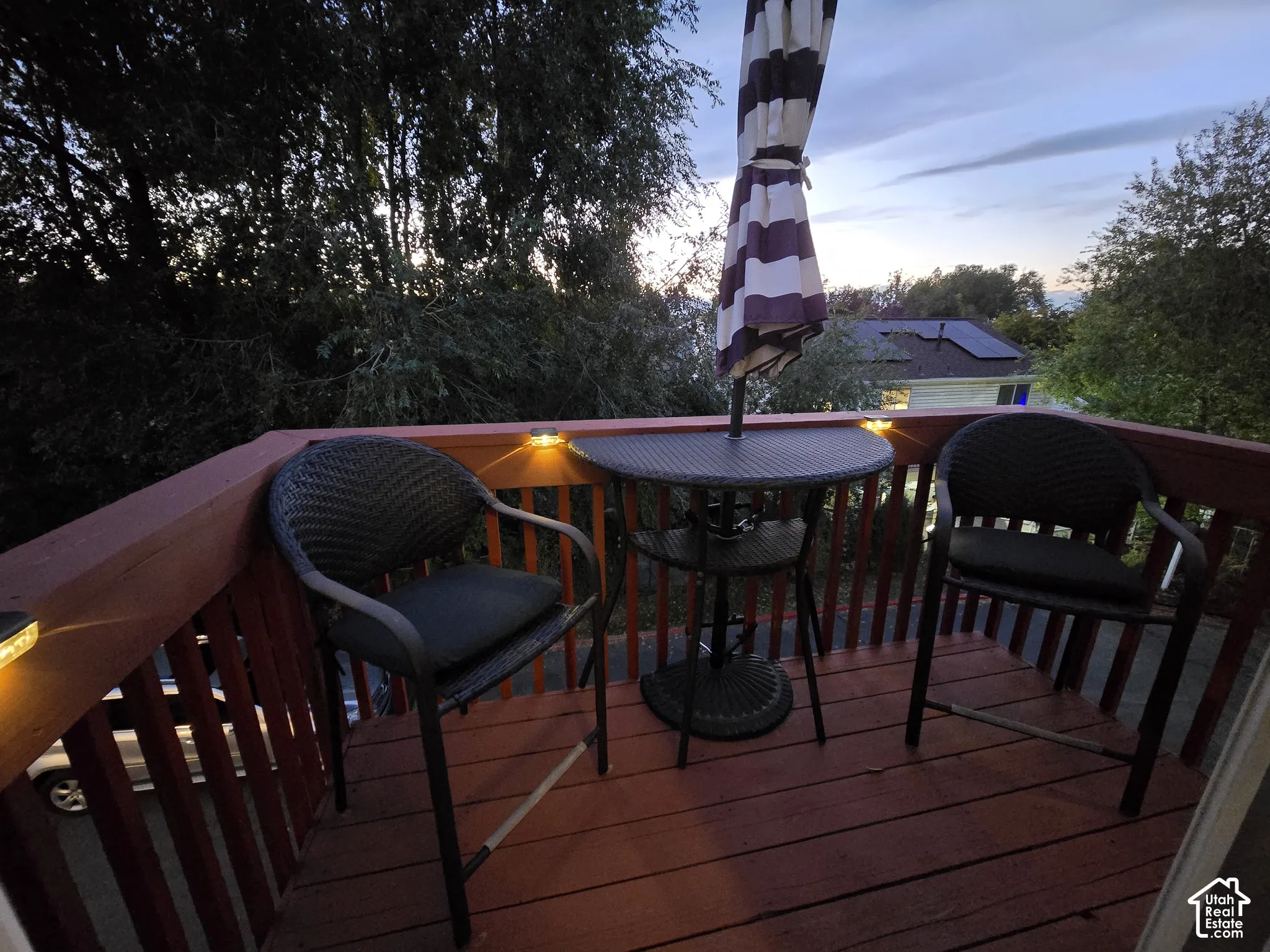 Elevated wooden deck featuring vertical balusters and integrated post-cap lighting