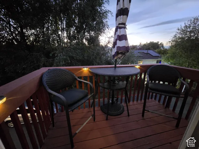 Elevated wooden deck featuring vertical balusters and integrated post-cap lighting