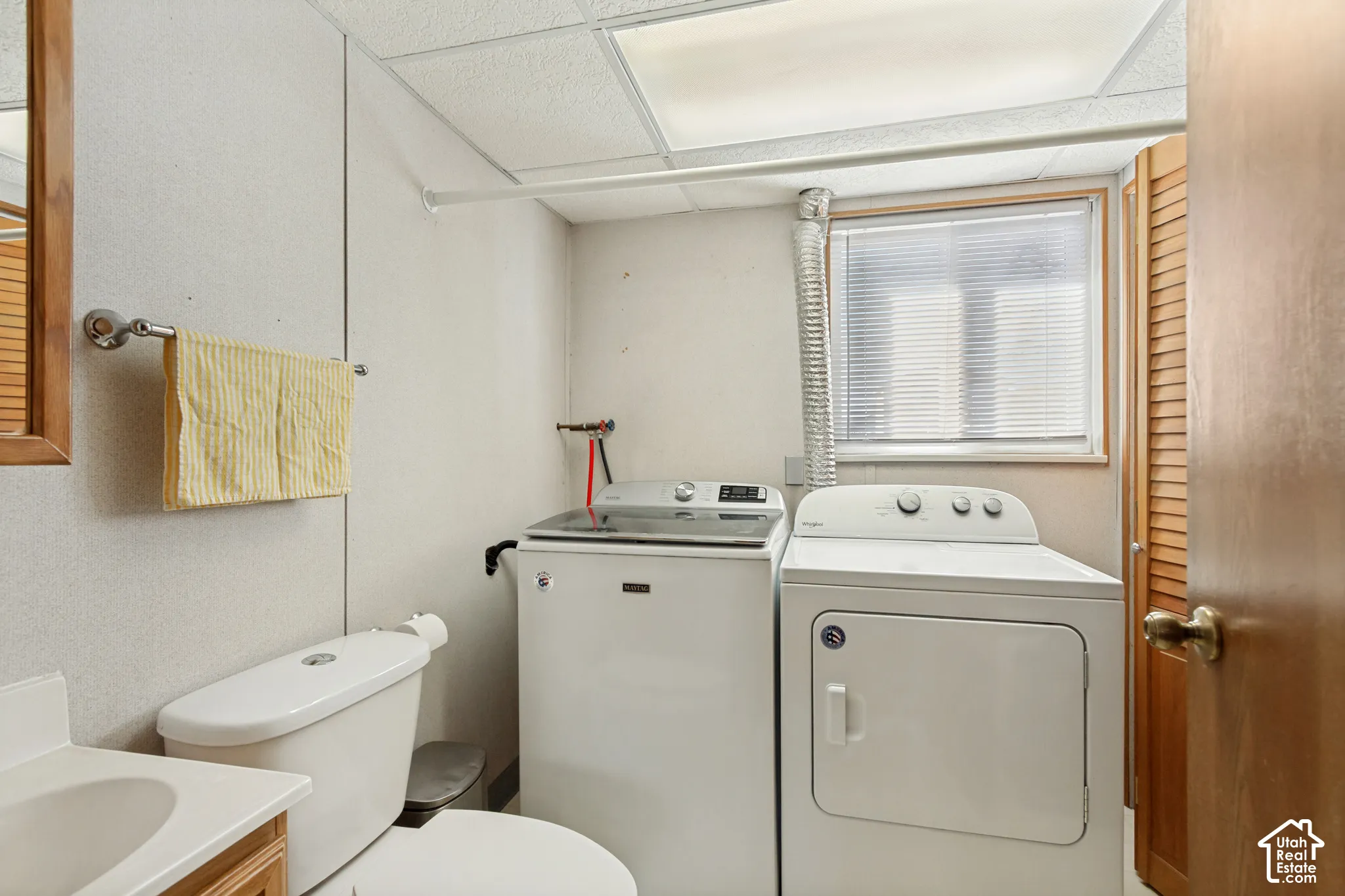 Utility space featuring a pedestal sink, dual-flush toilet, recessed lighting, and a louvered wooden closet door