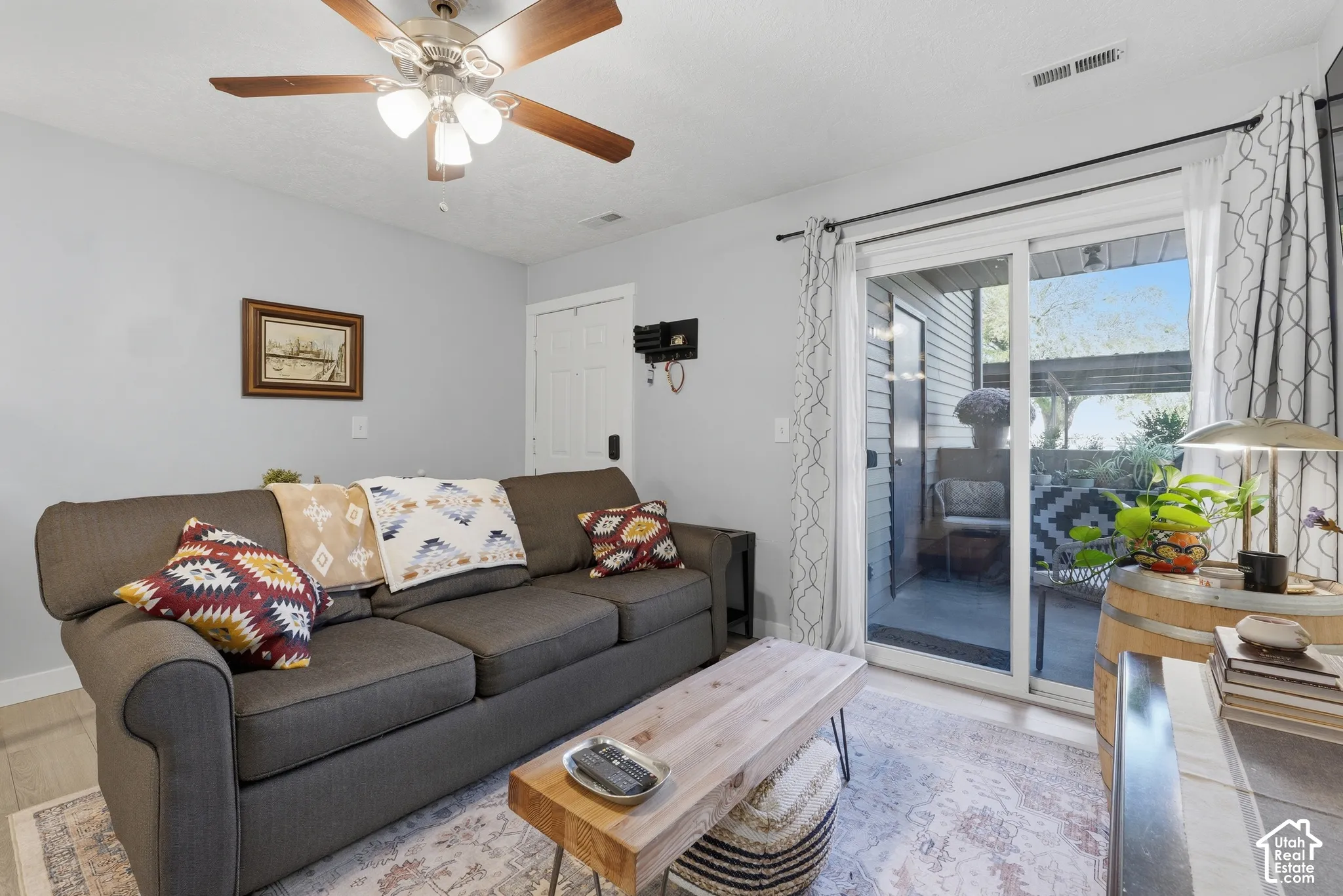 Sliding glass door, ceiling fan with integrated lighting, and neutral wall tones