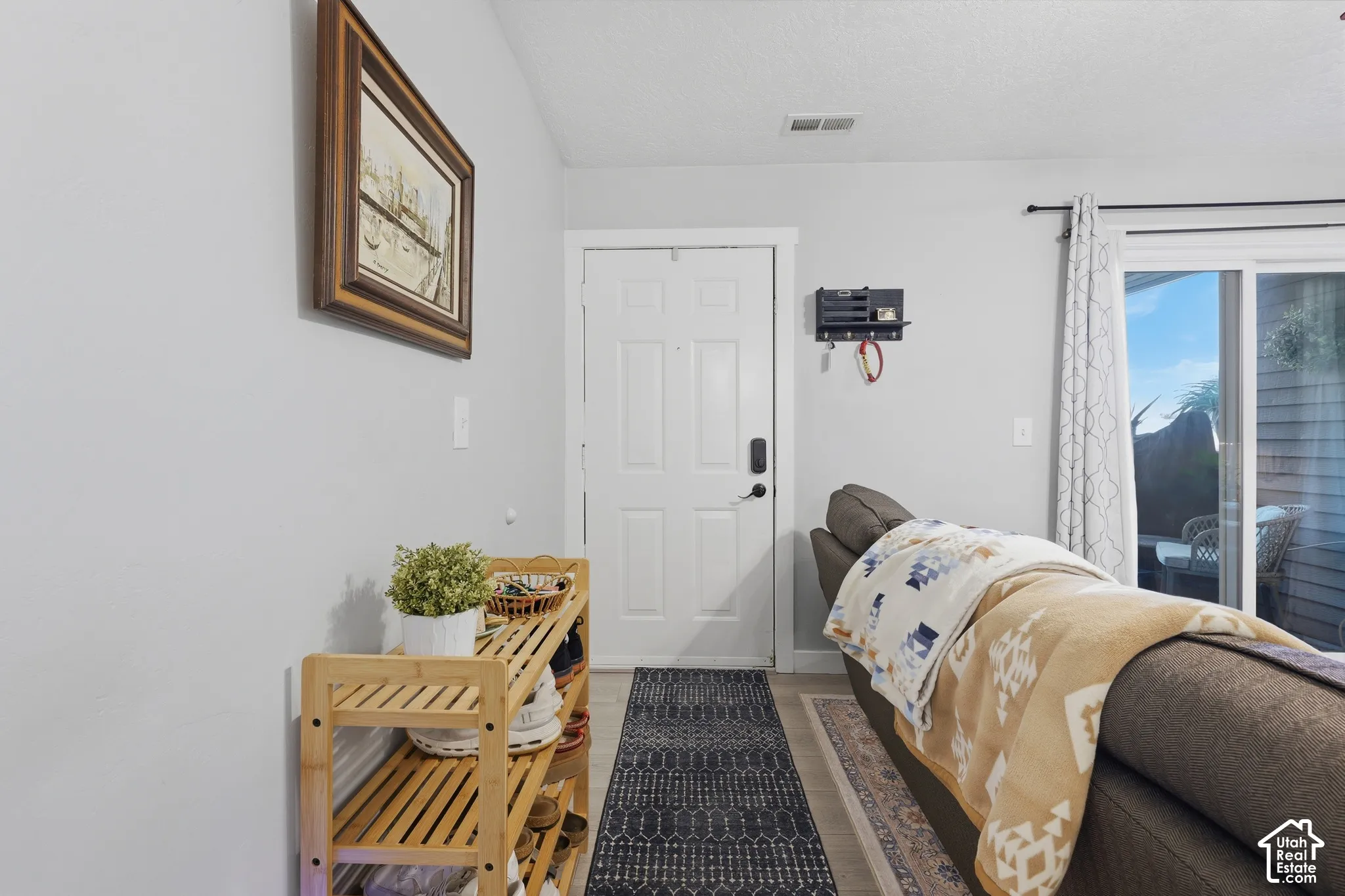 Entryway featuring light-toned flooring, a six-panel front door, and a sliding glass door providing natural light