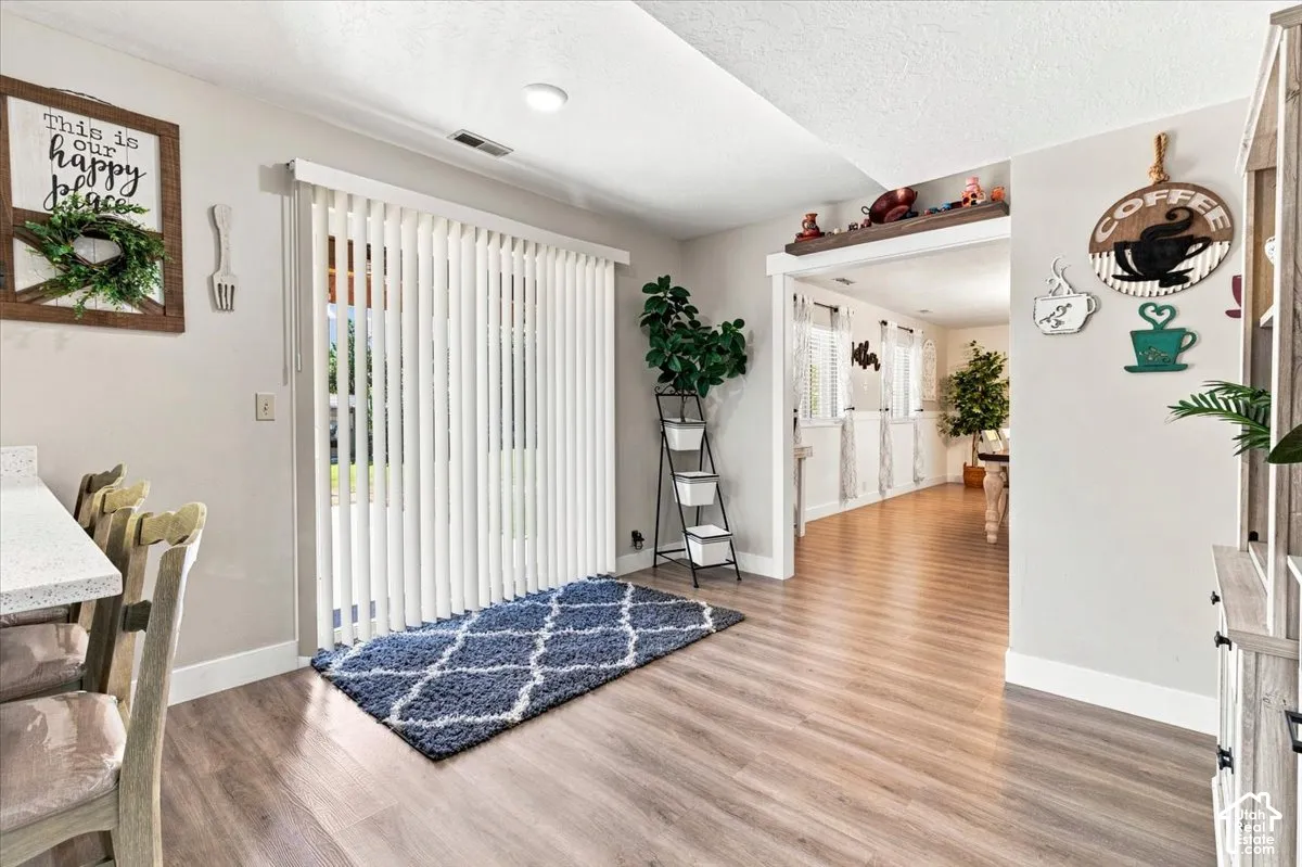 Wood-finish flooring, vertical slat blinds, and a built-in quartz countertop surface