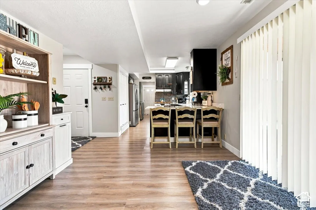 Interior space featuring wood-finish flooring, kitchen island with built-in cabinetry, and vertical window blinds