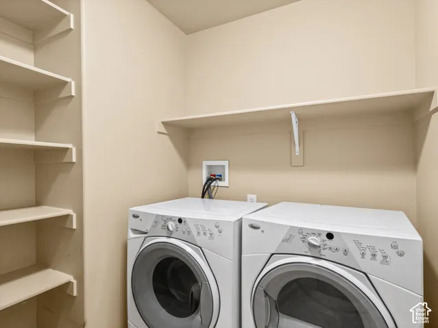Laundry area featuring built-in open shelving and an overhead storage ledge