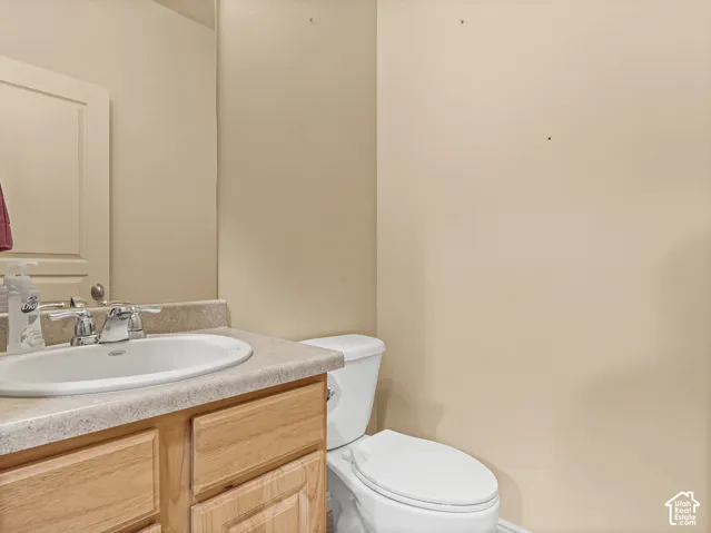 Wood-finish vanity featuring an integrated countertop, inset sink, polished chrome faucet, and expansive wall-mounted mirror
