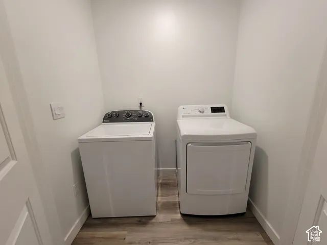 Laundry area featuring wood-finish flooring and dedicated hookups for washer and dryer units