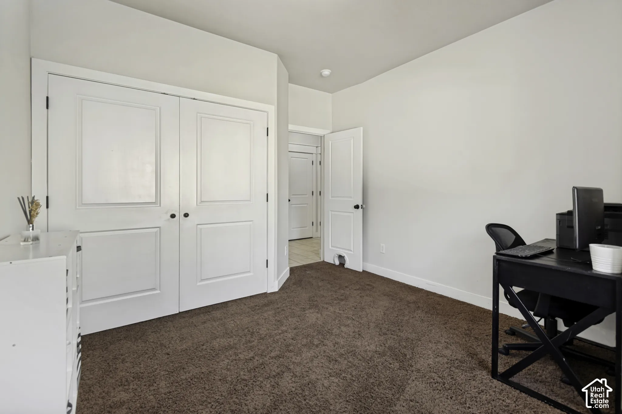 Room featuring high ceilings, neutral wall tones, carpeted flooring, and double-panel doors with matte black hardware