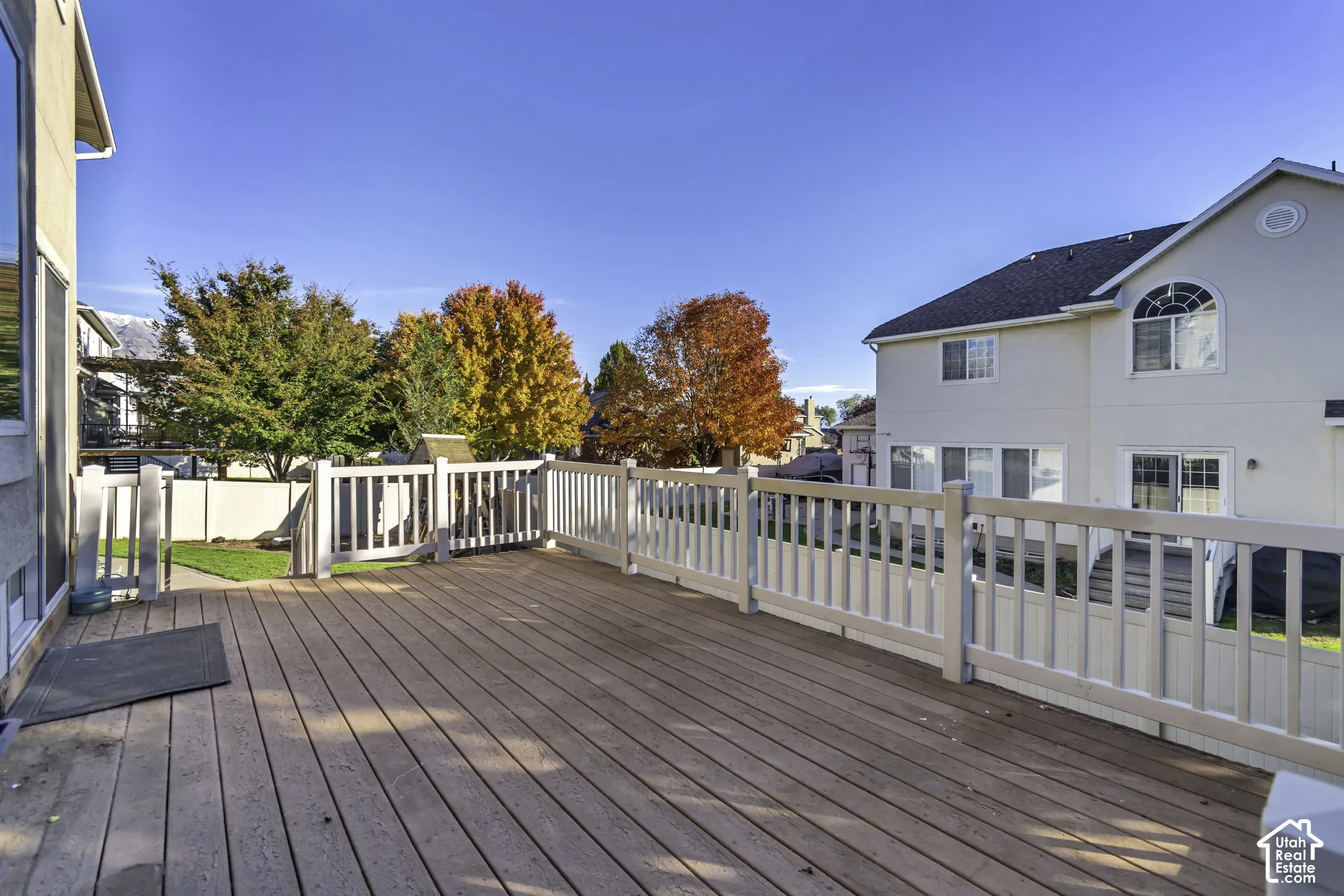 Raised composite deck featuring a light-toned vinyl railing system