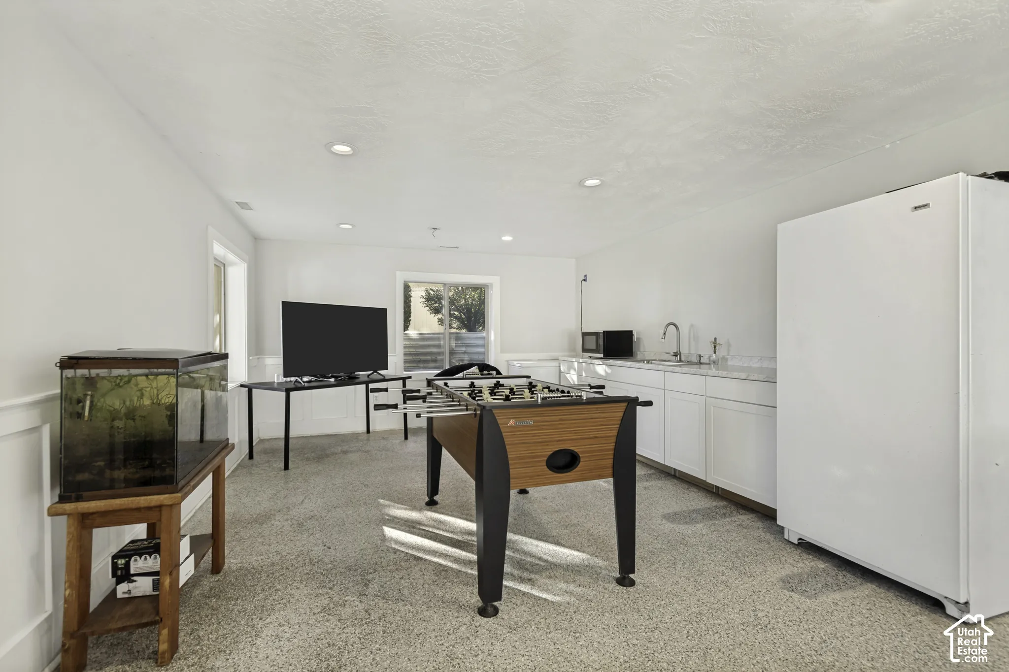 Kitchenette featuring white cabinetry, stone-finish countertops, stainless steel sink with gooseneck faucet, and recessed lighting