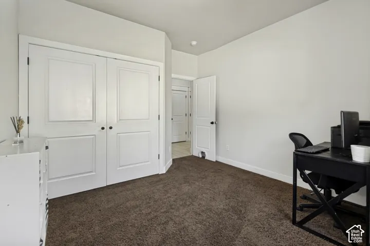 Room featuring high ceilings, neutral wall tones, carpeted flooring, and double-panel doors with matte black hardware