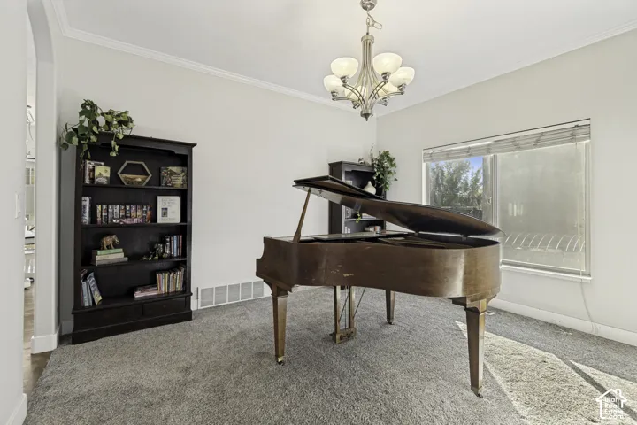 Room featuring crown molding, neutral carpeting, a multi-light polished nickel chandelier, and a large horizontal window