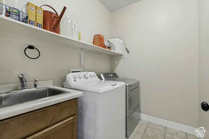 Utility space featuring a drop-in stainless steel sink, wood-finish cabinetry, neutral countertop, and overhead storage shelving